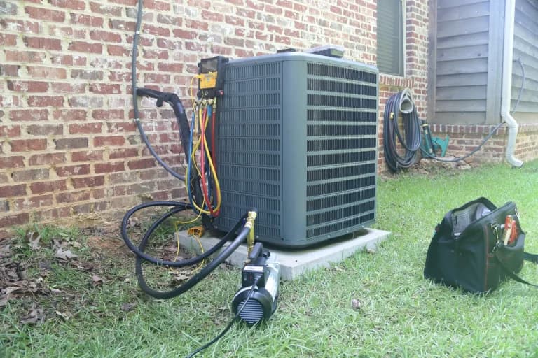 AC technician repairing an air conditioning unit
